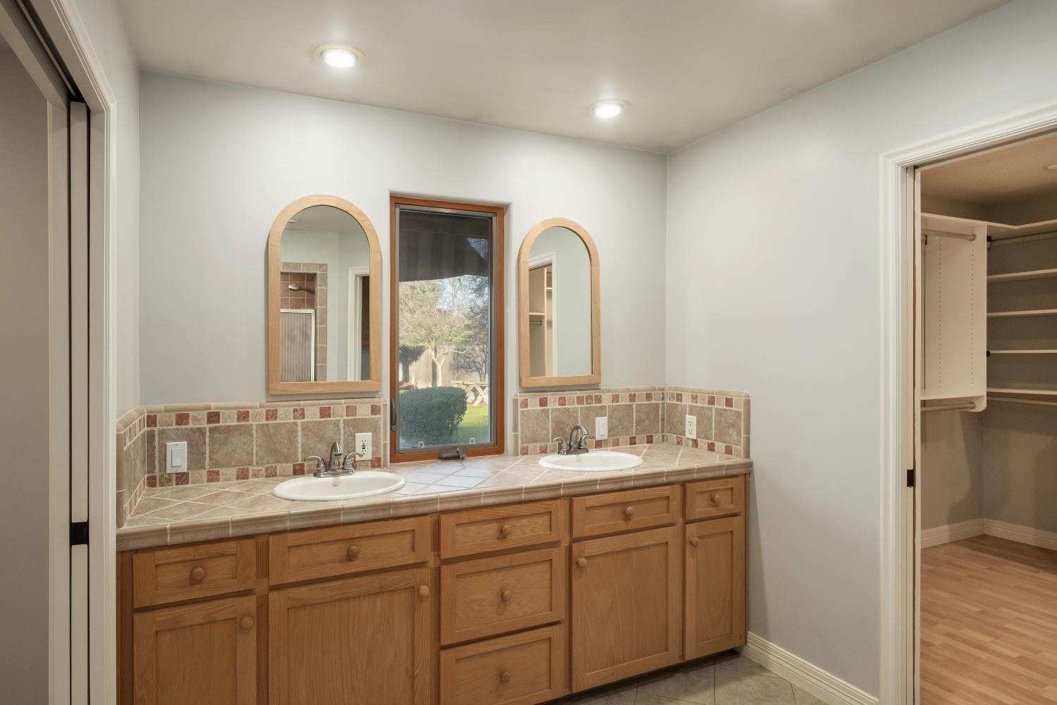 19282 East South Avenue Reedley, CA 93654 - Photo 22 of 33 a bathroom with double vanity sinks and a mirror