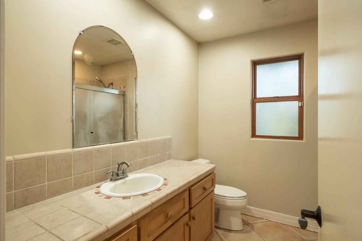 19282 East South Avenue Reedley, CA 93654 - Photo 26 of 33 a bathroom with a granite countertop sink toilet and mirror