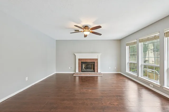 a view of an empty room with a window and a fireplace