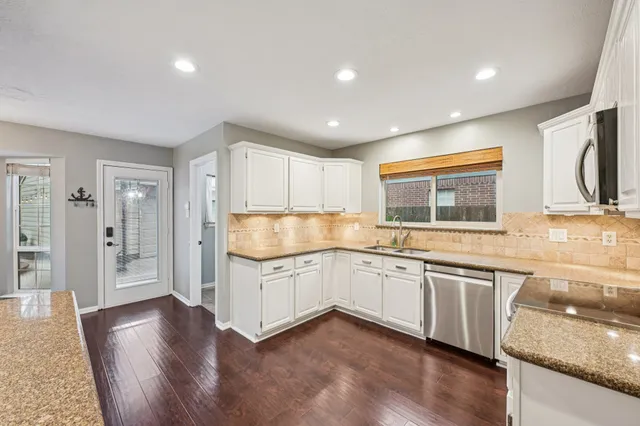 a kitchen with granite countertop a sink and cabinets