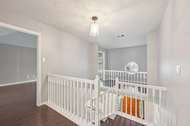 a view of staircase with railing and white walls