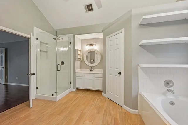 a bathroom with a tub sink and mirror