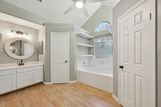 a bathroom with a sink a bathtub and a window