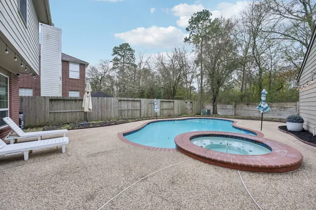 a view of a swimming pool with sitting area in front of house