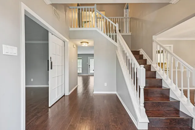 a view of front door with wooden floor and stairs