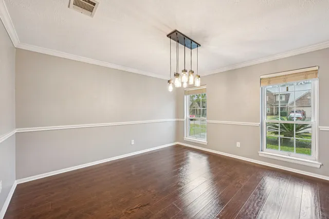 a view of wooden floor chandelier and window in a room