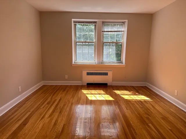 a view of a room with wooden floor and a window
