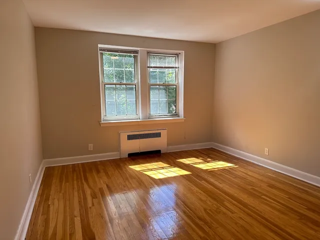 a view of a room with wooden floor and a window