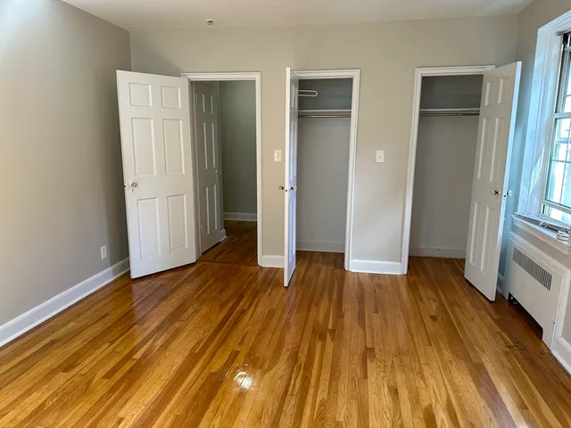 an empty room with wooden floor and entrance