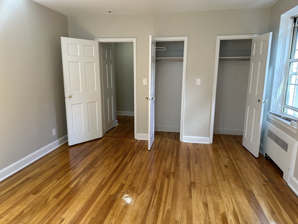 24 Concord Avenue, Unit 111 Cambridge, MA 02138 - Photo 13 of 17 an empty room with wooden floor and entrance