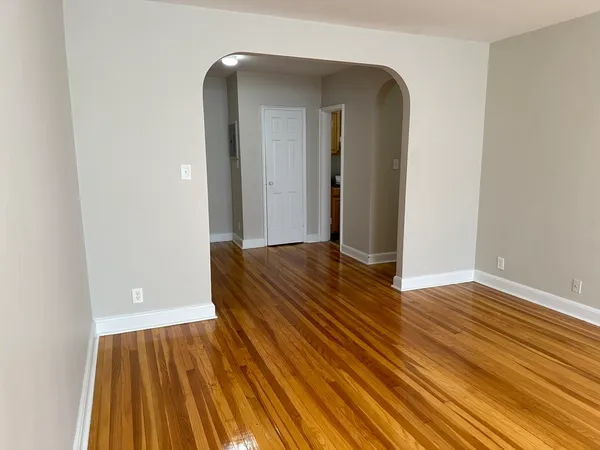a view of a room with wooden floor and door