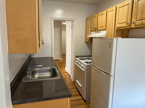a kitchen with a refrigerator a stove a sink and a window