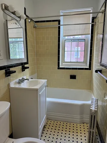 a bathroom with a granite countertop sink a toilet and shower