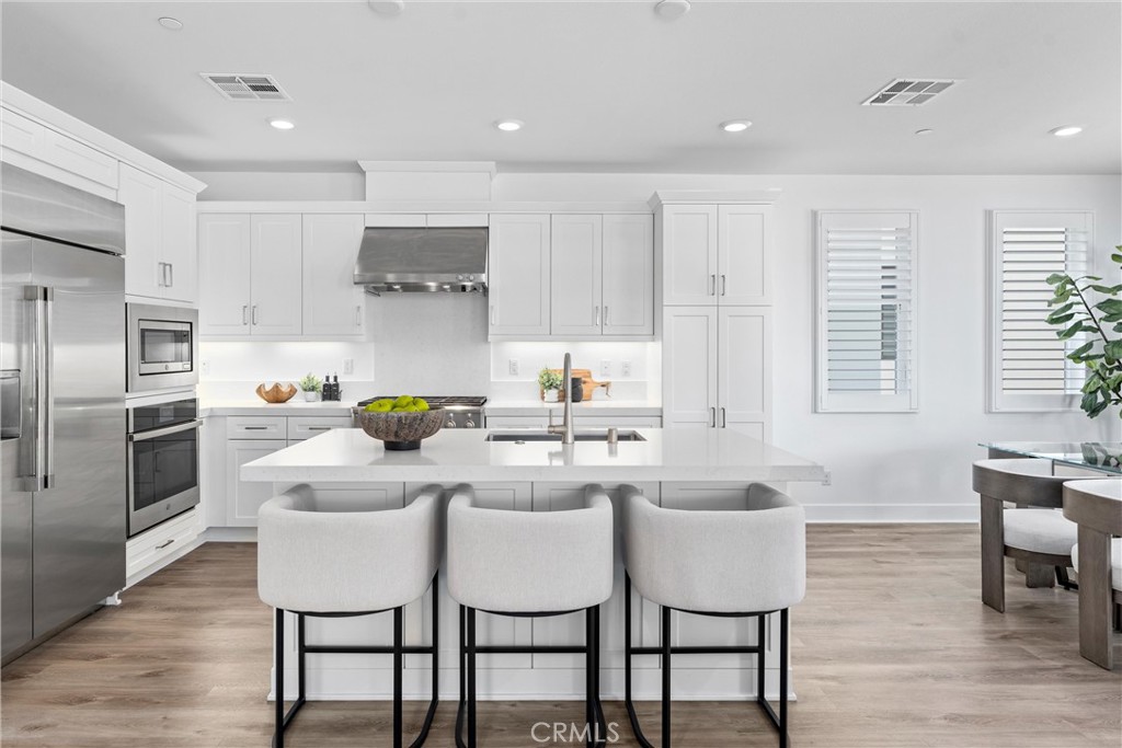 22 Transport Tustin, CA 92782 - Photo 2 of 44 a kitchen with a dining table chairs refrigerator and cabinets