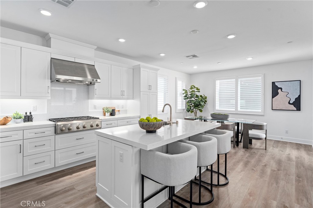 22 Transport Tustin, CA 92782 - Photo 3 of 44 a kitchen with stainless steel appliances a table and chairs in it