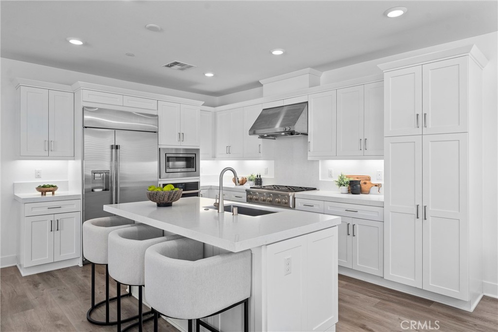 22 Transport Tustin, CA 92782 - Photo 4 of 44 a kitchen with stainless steel appliances a sink a stove a refrigerator cabinets and chairs