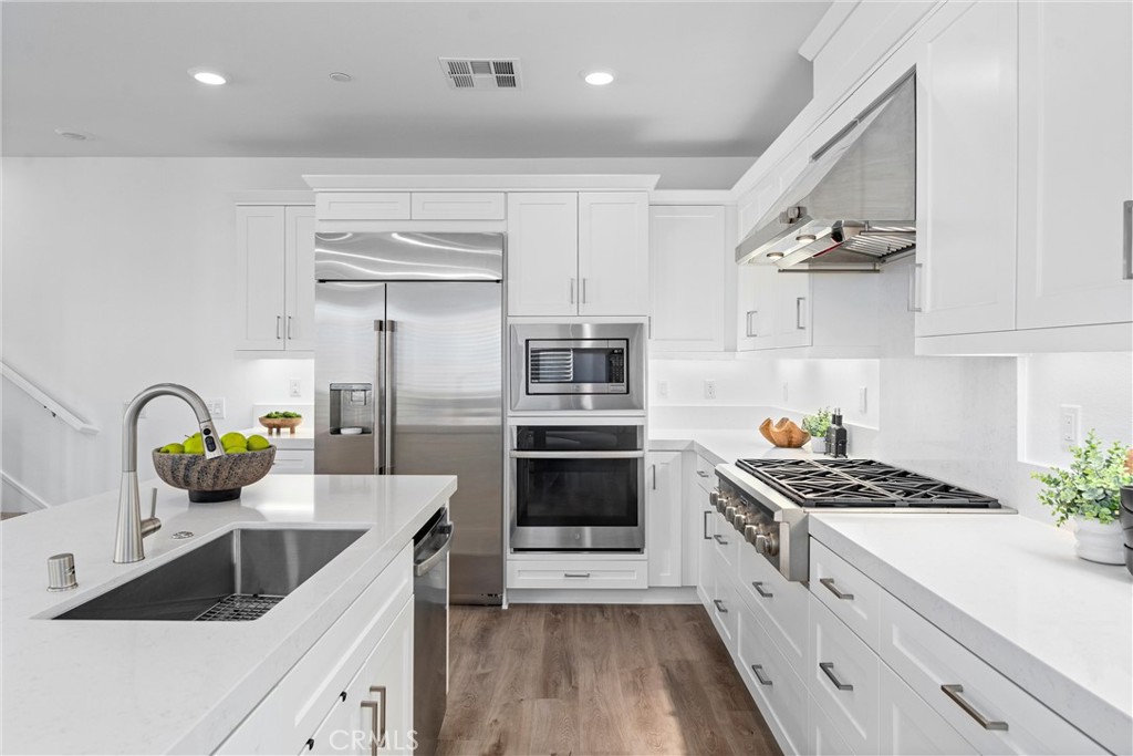 22 Transport Tustin, CA 92782 - Photo 5 of 44 a kitchen with granite countertop a stove and a sink