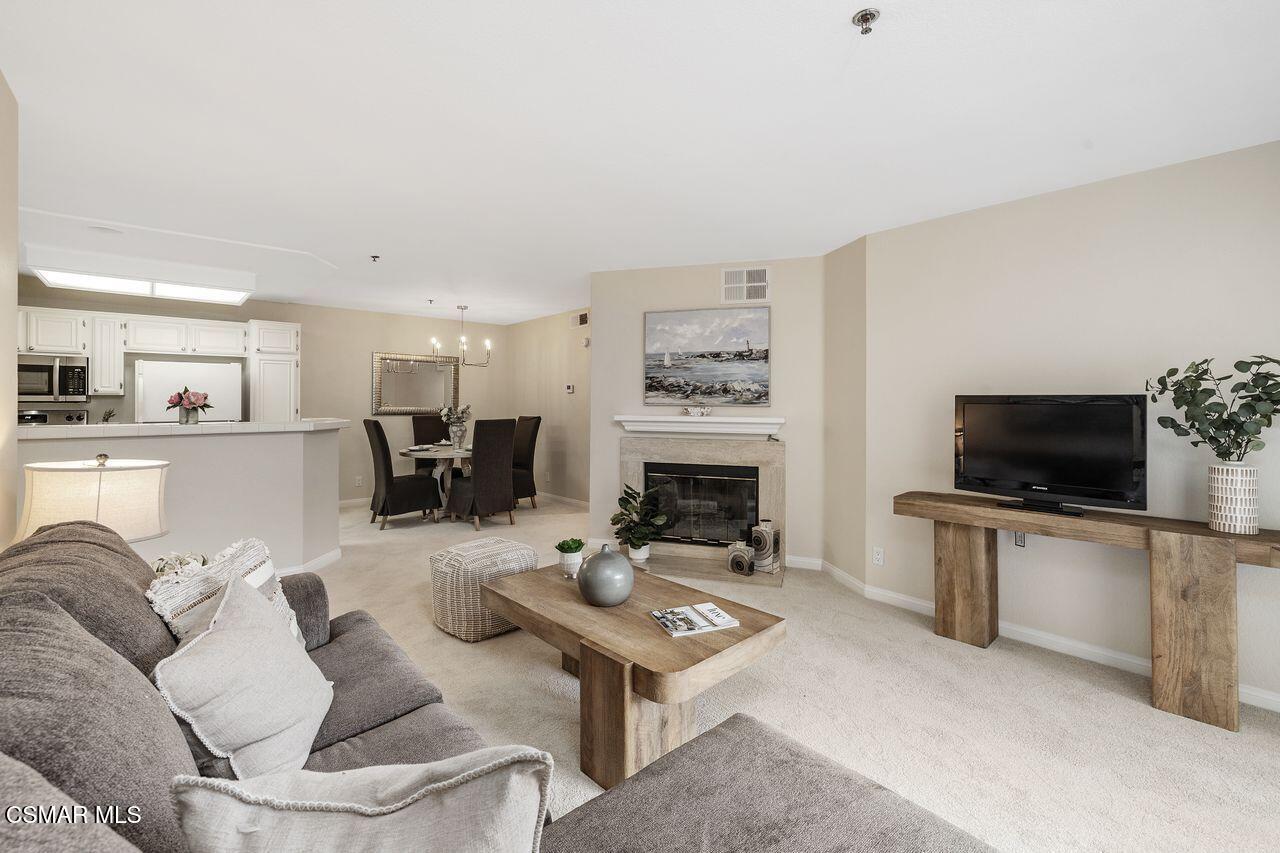 697 Sutton Crest Trail, Unit 302 Oak Park, CA 91377 - Photo 1 of 47 a living room with furniture a flat screen tv and a fireplace