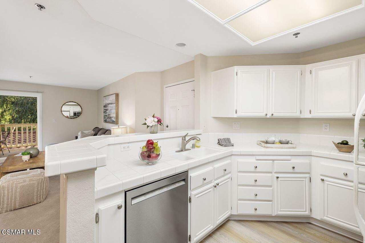 697 Sutton Crest Trail, Unit 302 Oak Park, CA 91377 - Photo 12 of 47 a kitchen with white cabinets and appliances