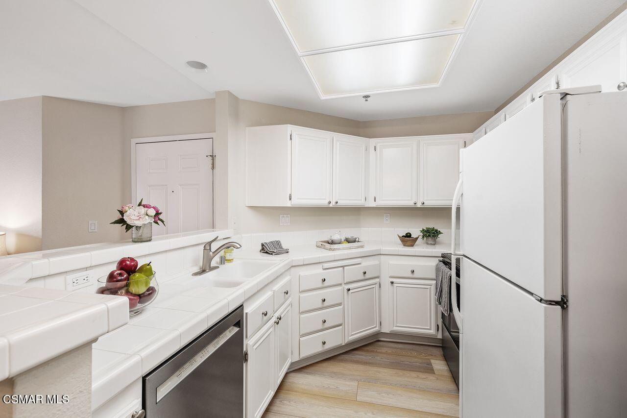 697 Sutton Crest Trail, Unit 302 Oak Park, CA 91377 - Photo 15 of 47 a kitchen with a sink cabinets and appliances