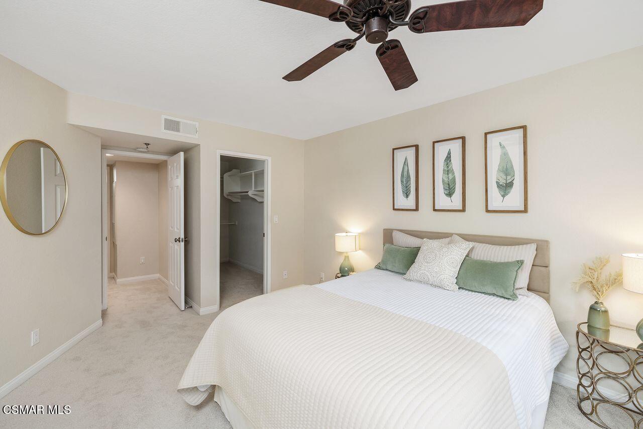 697 Sutton Crest Trail, Unit 302 Oak Park, CA 91377 - Photo 17 of 47 a bedroom with a bed and a chandelier