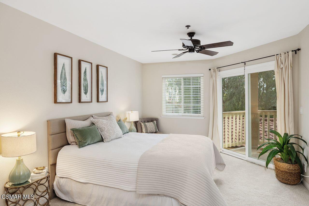 697 Sutton Crest Trail, Unit 302 Oak Park, CA 91377 - Photo 18 of 47 a bedroom with a large bed and a chandelier fan