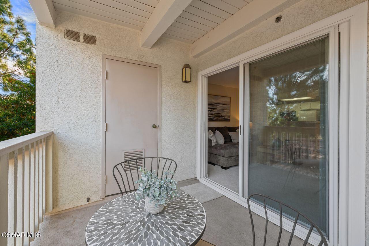697 Sutton Crest Trail, Unit 302 Oak Park, CA 91377 - Photo 28 of 47 a view of a hallway with wooden floor and a livingroom