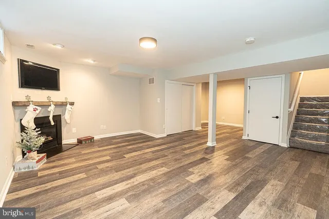 a view of a livingroom with wooden floor and a flat screen tv