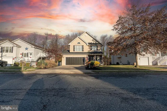 a view of white house with a big yard and large trees