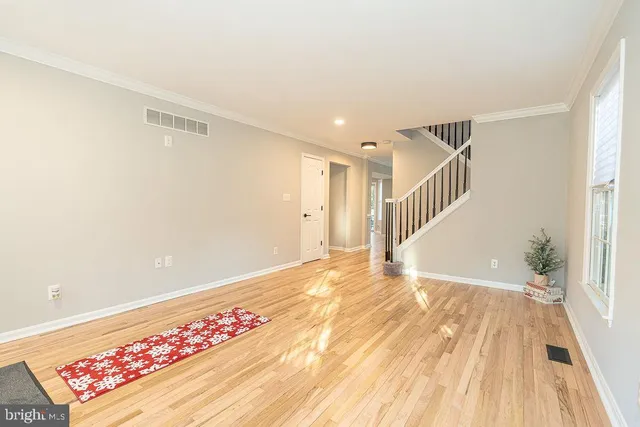 a view of an empty room with wooden floor