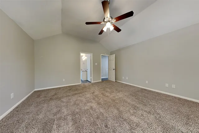 a view of an empty room with a chandelier fan