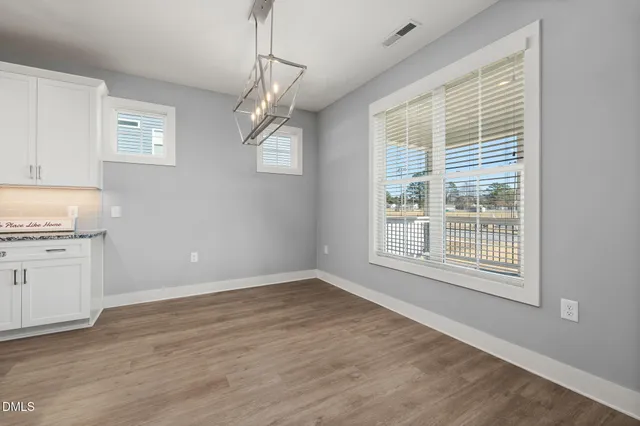 a large kitchen with stainless steel appliances granite countertop a large counter top and a stove with wooden floor