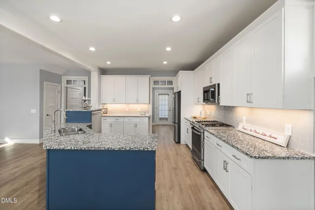 a kitchen with white cabinets and stainless steel appliances