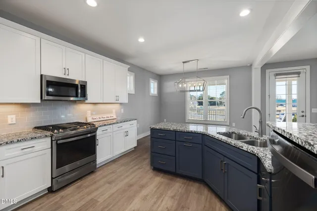 a kitchen with granite countertop a sink stainless steel appliances and cabinets