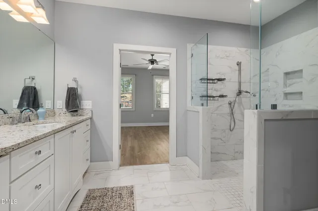 a bathroom with a granite countertop sink a light fixture and a mirror