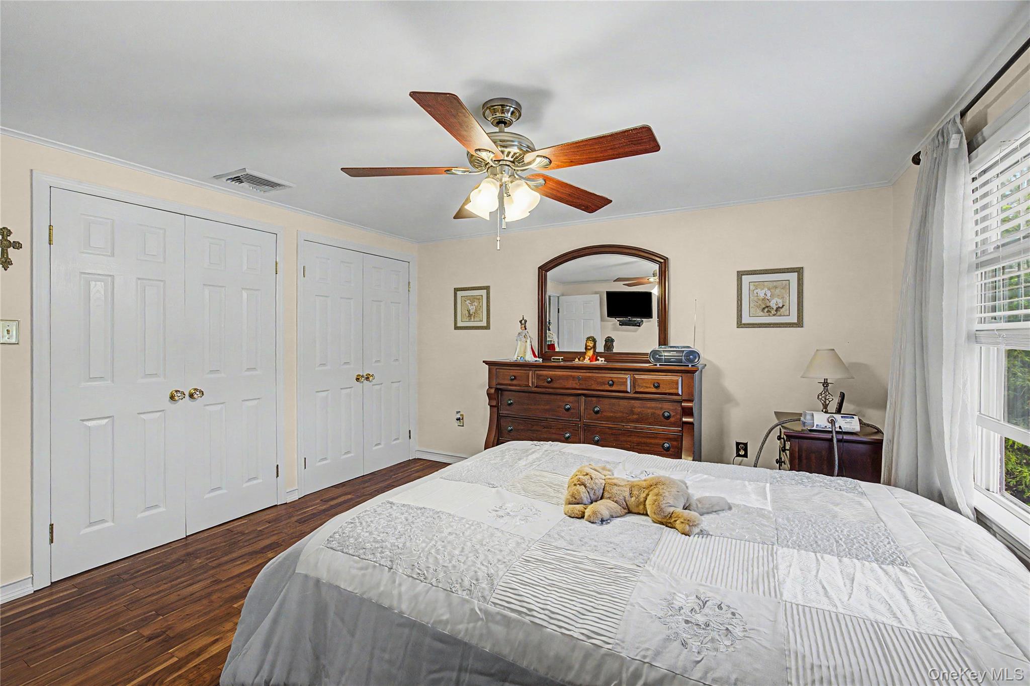 9 South Pond Trail Ridge, NY 11961 - Photo 15 of 40 a bedroom with a bed and a chandelier