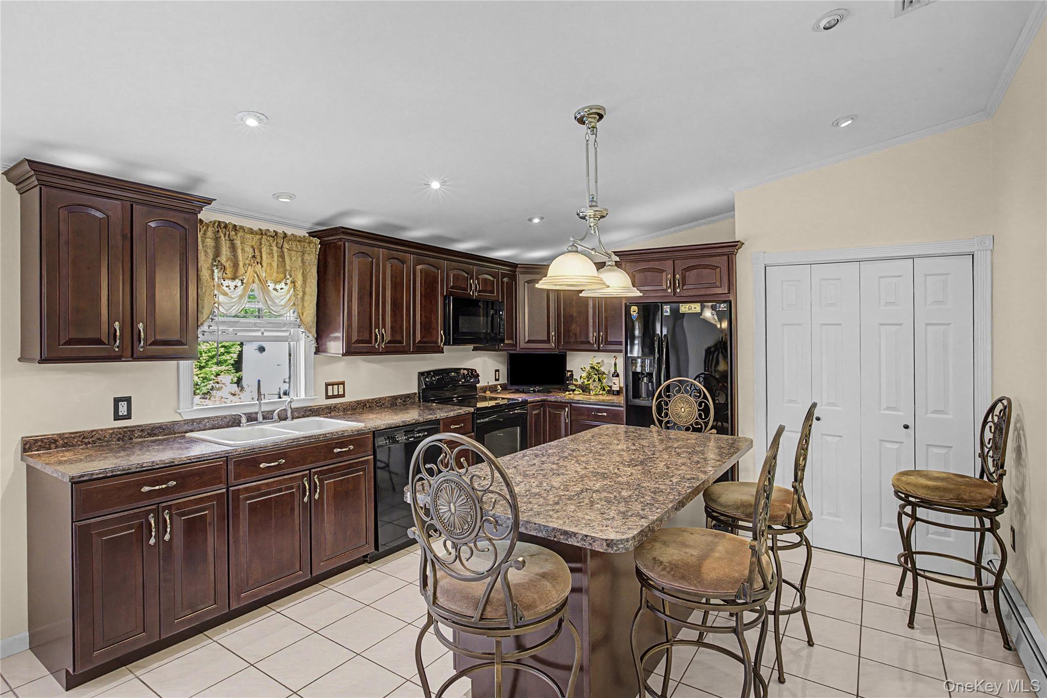 9 South Pond Trail Ridge, NY 11961 - Photo 31 of 40 a kitchen with stainless steel appliances granite countertop a table chairs sink and cabinets