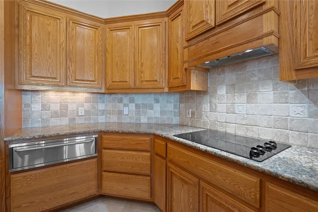 a kitchen with granite countertop cabinets and steel stainless steel appliances