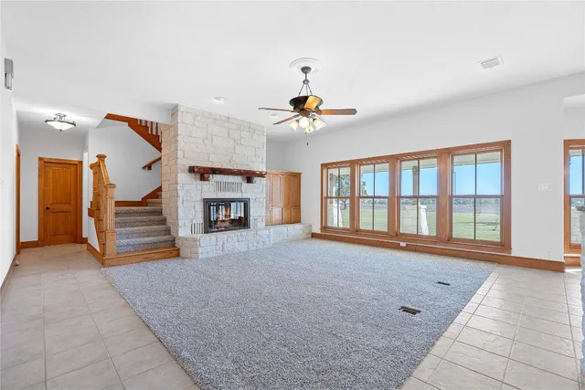 a view of an empty room with a fireplace and a window
