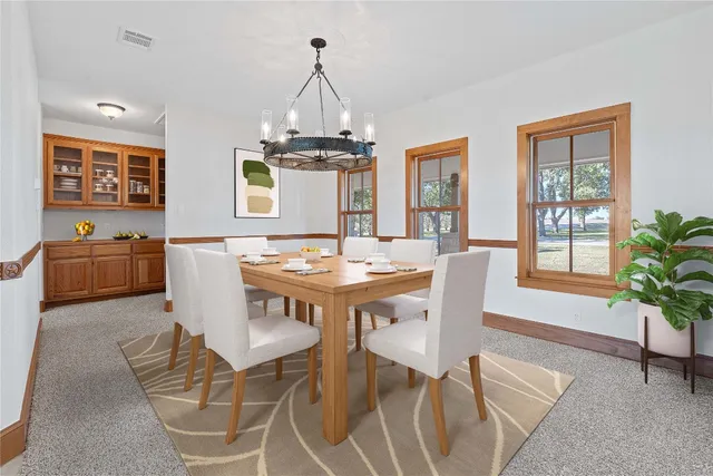 a view of a dining room with furniture and chandelier