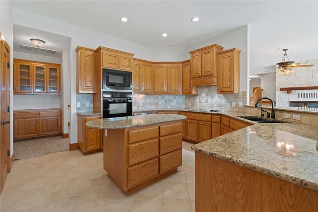 a kitchen with stainless steel appliances granite countertop a sink and a stove
