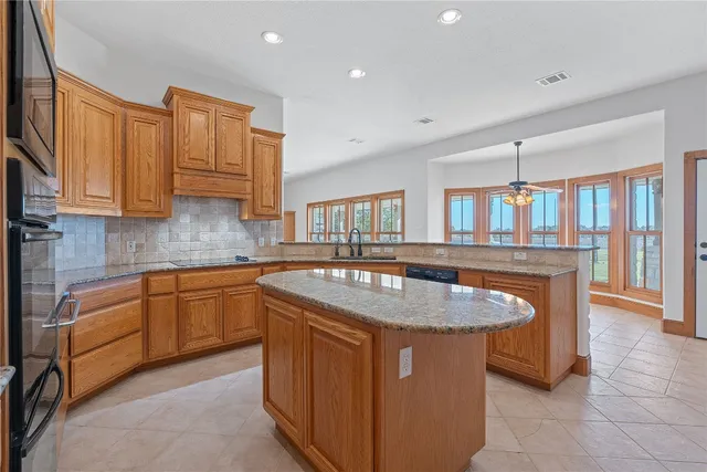 a kitchen with stainless steel appliances granite countertop a sink dishwasher and cabinets with wooden floor