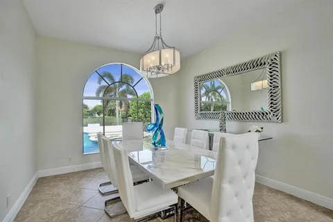 a view of a patio with lawn chairs floor to ceiling window and outdoor kitchen