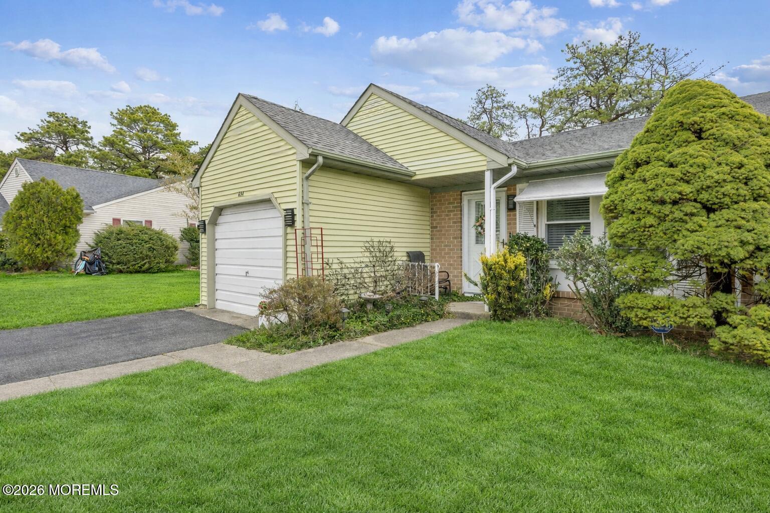 a view of a house with a yard and potted plants