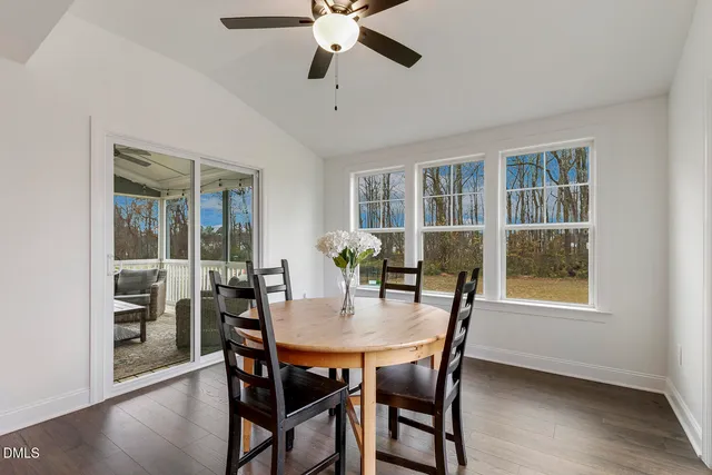 a kitchen with a table chairs wooden floor and stainless steel appliances