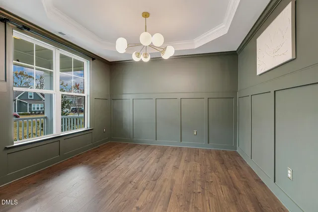a dining room with furniture window and wooden floor