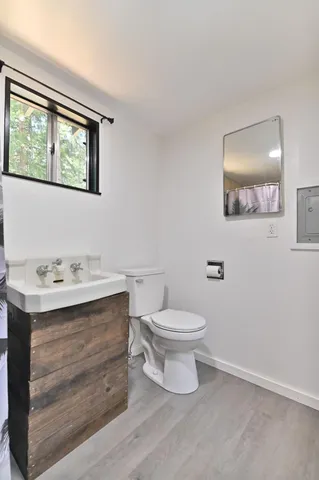 a bathroom with a toilet a sink and mirror