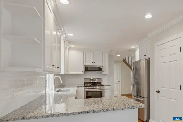 a kitchen with a refrigerator and a stove top oven