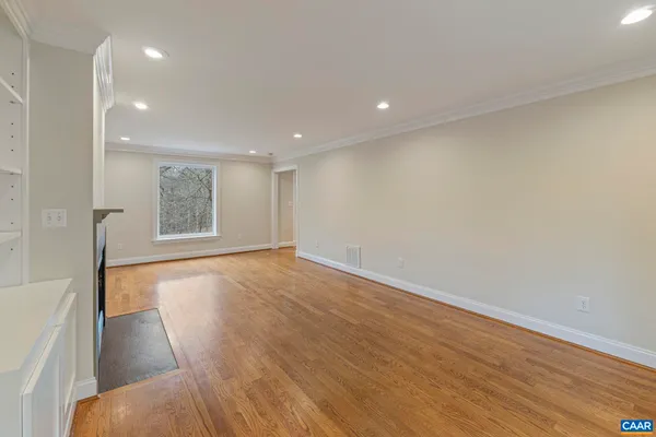 a view of an empty room with wooden floor