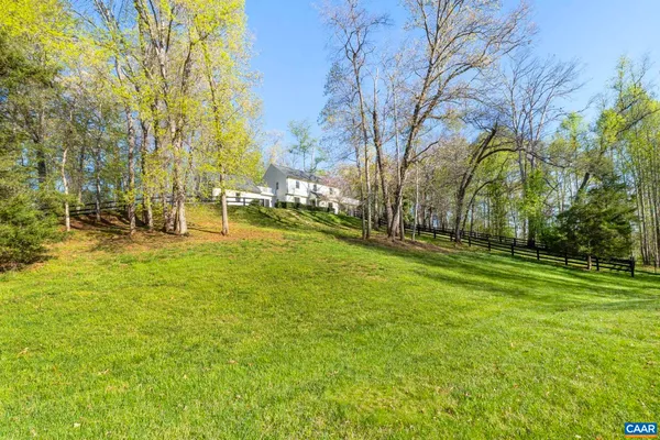 a backyard of a house with lots of green space and fountain